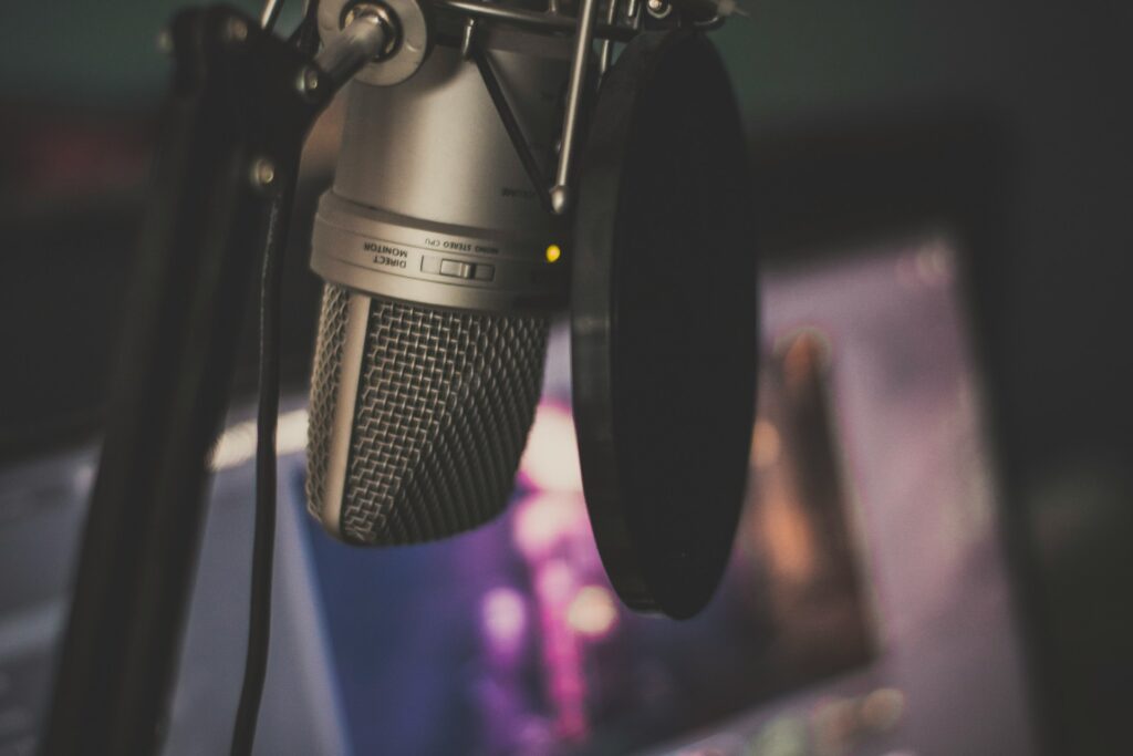 focus photography of gray condenser microphone and pop filter