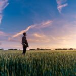 man on grass field looking at sky