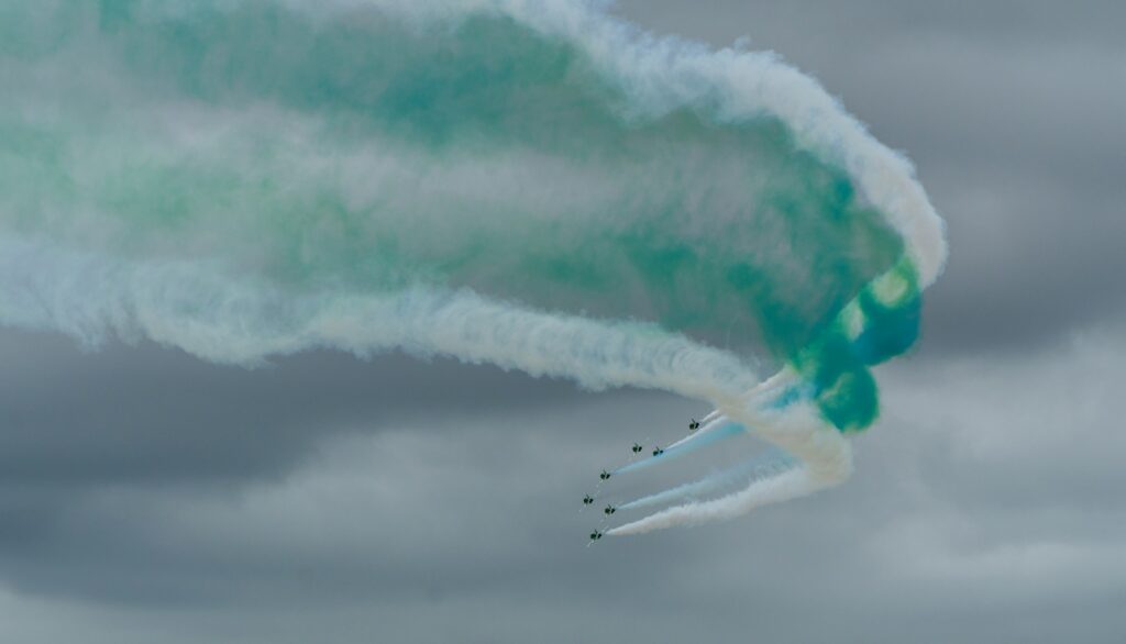 A couple of jets flying through a cloudy sky
