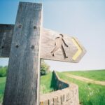 brown wooden cross with arrow sign